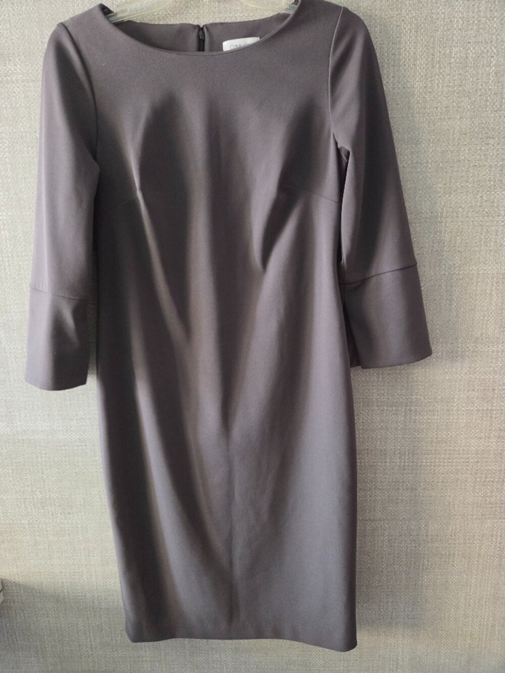 The Calvin Klein gray dress features a crew neck, 3/4 sleeves, size 8.